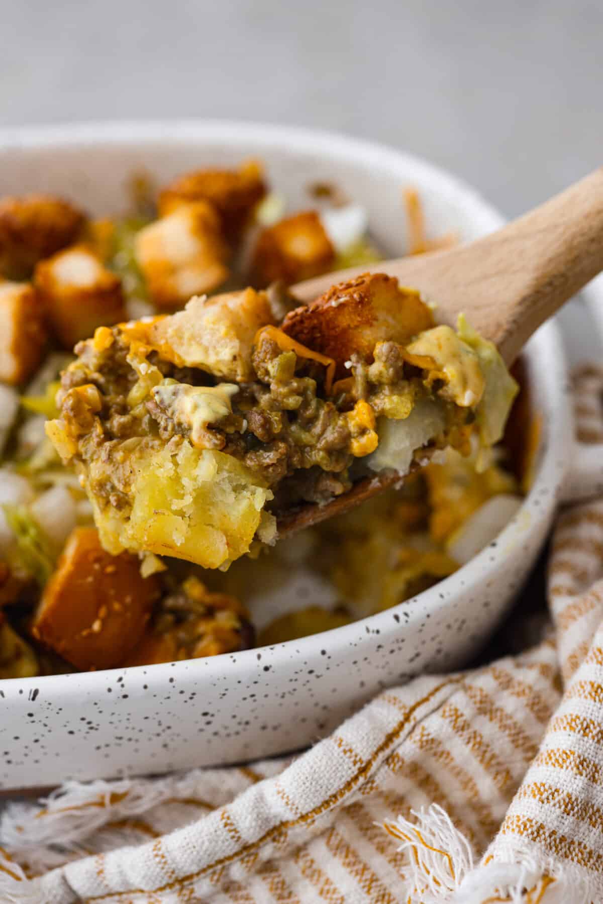 Meaty, cheesy, and chock full of tasty mix-ins like hash browns, pickles, and onions, Big Mac casserole is the perfect dinner to make this week! Itโs an easy, deconstructed version of the classic burger we all know and love. A scoop of casserole on a wooden spoon.