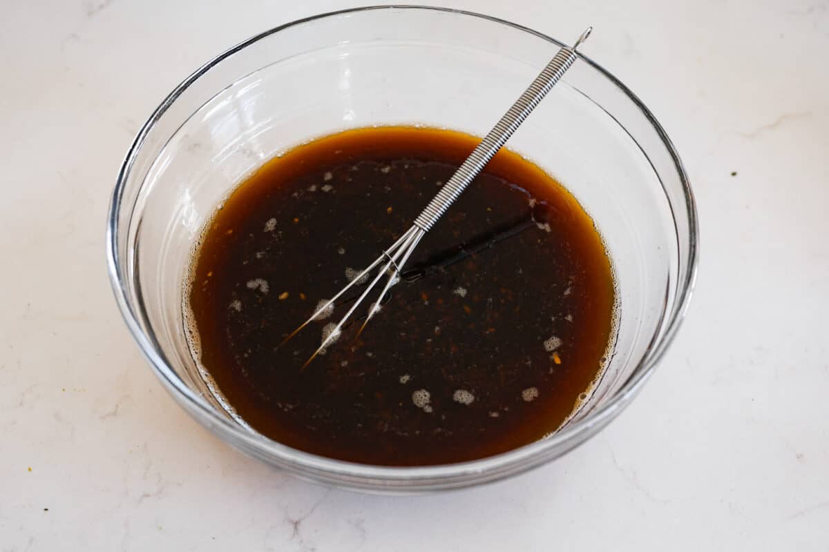 This delicious bourbon marinade will add wonderful depth of flavor and tenderize any meat you're cooking, from steak to chicken! This recipe uses ingredients like brown sugar, Worcestershire sauce, apple cider vinegar, garlic and bourbon to infuse each piece of meat with the perfect savory, sweet and tangy flavor. All of the ingredients being mixed together.