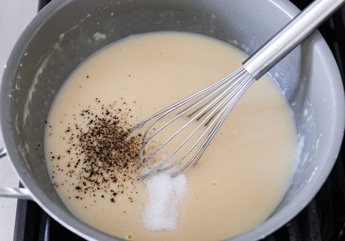 Bring all the best things about Southern cooking to your dinner table with this country fried chicken recipe! The result? Golden, crispy goodness smothered in savory homemade gravy. The gravy mixture being whisked together.