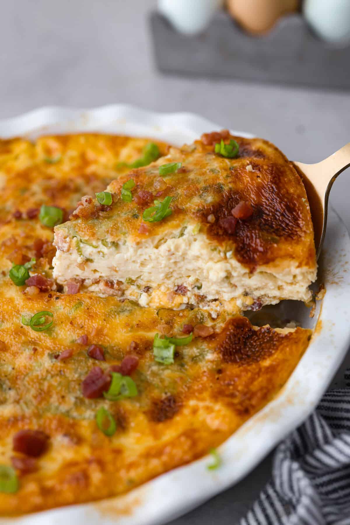 Rich and savory, Crustless Quiche is easy to make with a mix of bacon, green onions, egg custard and cheese, all baked to perfection without the hassle of a pie crust. Fluffy, creamy and filled with incredible flavor, it's great for breakfast or any meal of the day! A slice of crustless quiche.