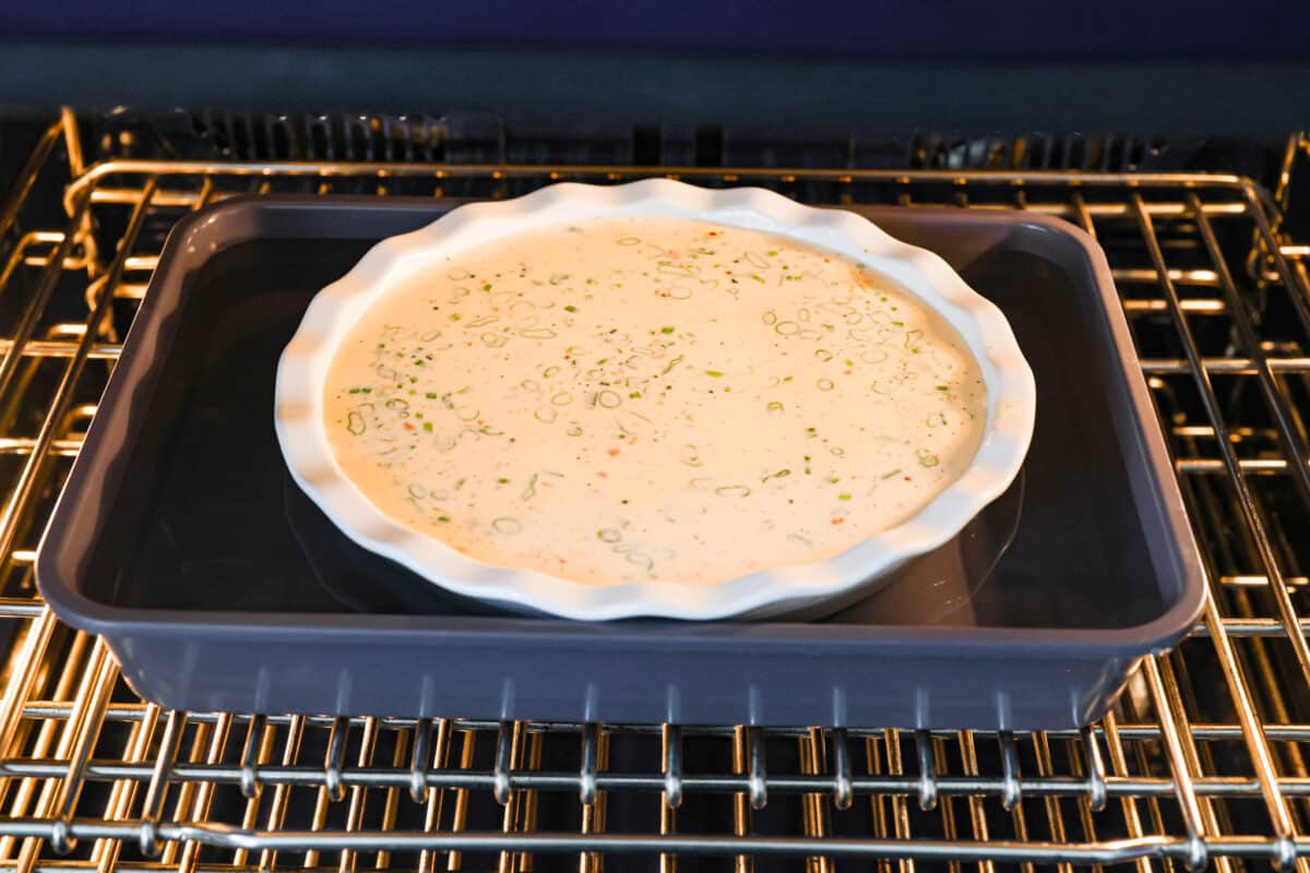 Rich and savory, Crustless Quiche is easy to make with a mix of bacon, green onions, egg custard and cheese, all baked to perfection without the hassle of a pie crust. Fluffy, creamy and filled with incredible flavor, it's great for breakfast or any meal of the day! The crustless quiche set into a water bath.