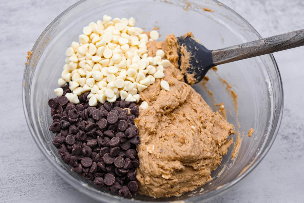 Win over everyoneโs heart (and stomach!) with these Marry Me Cookie Bars! They have the BEST flavor and texture, made with rolled oats, both white and semi-sweet chocolate chips, and a pinch of cinnamon! Chewy, creamy, chocolatey goodness! The white and semi-sweet chocolate chips being folded in.