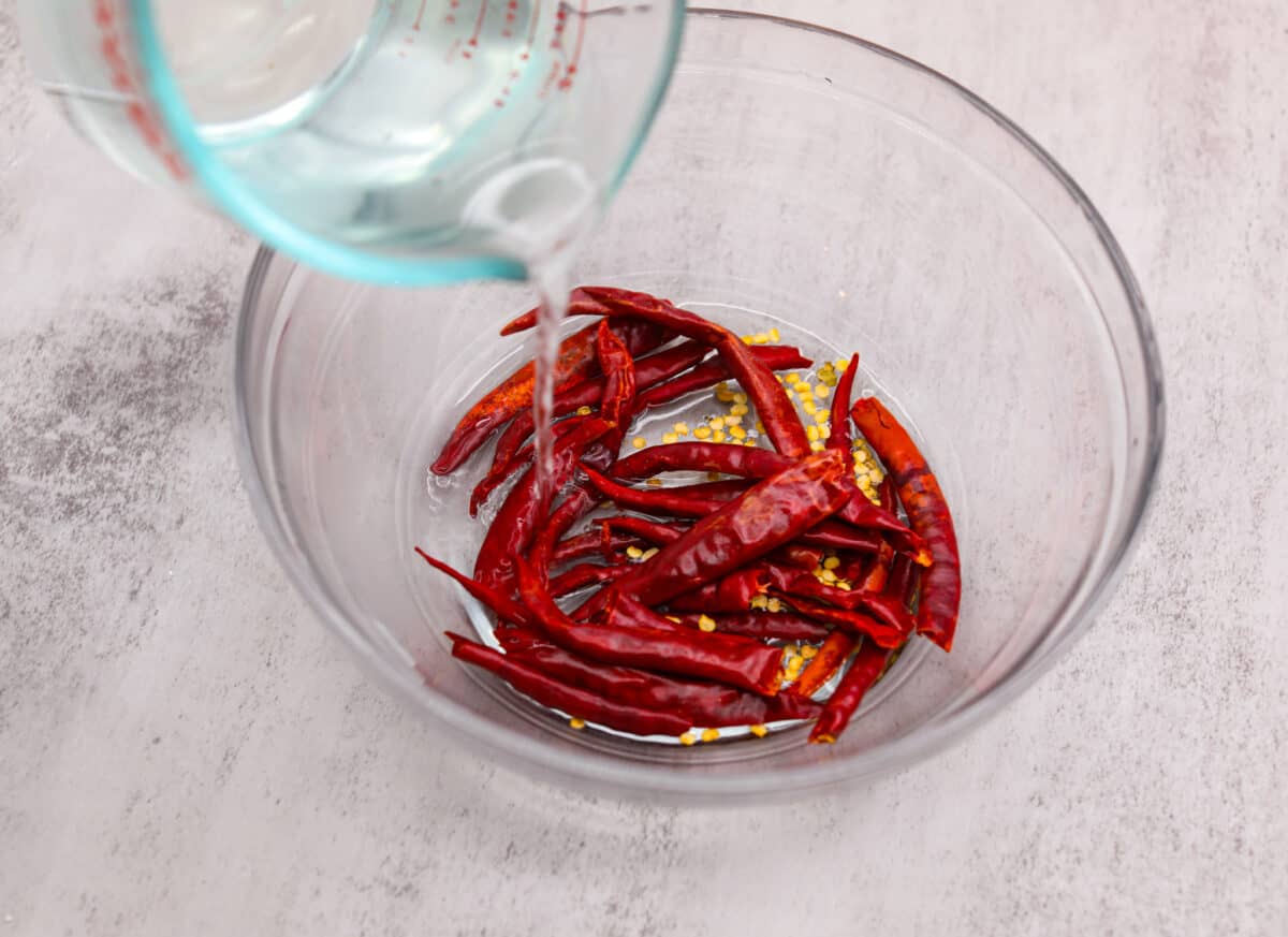 If hot sauce is something you use a lot in your kitchen, you have to try this homemade version! Tweak it to your liking then use it to upgrade all of your favorite dishes! Covering dried peppers with water.