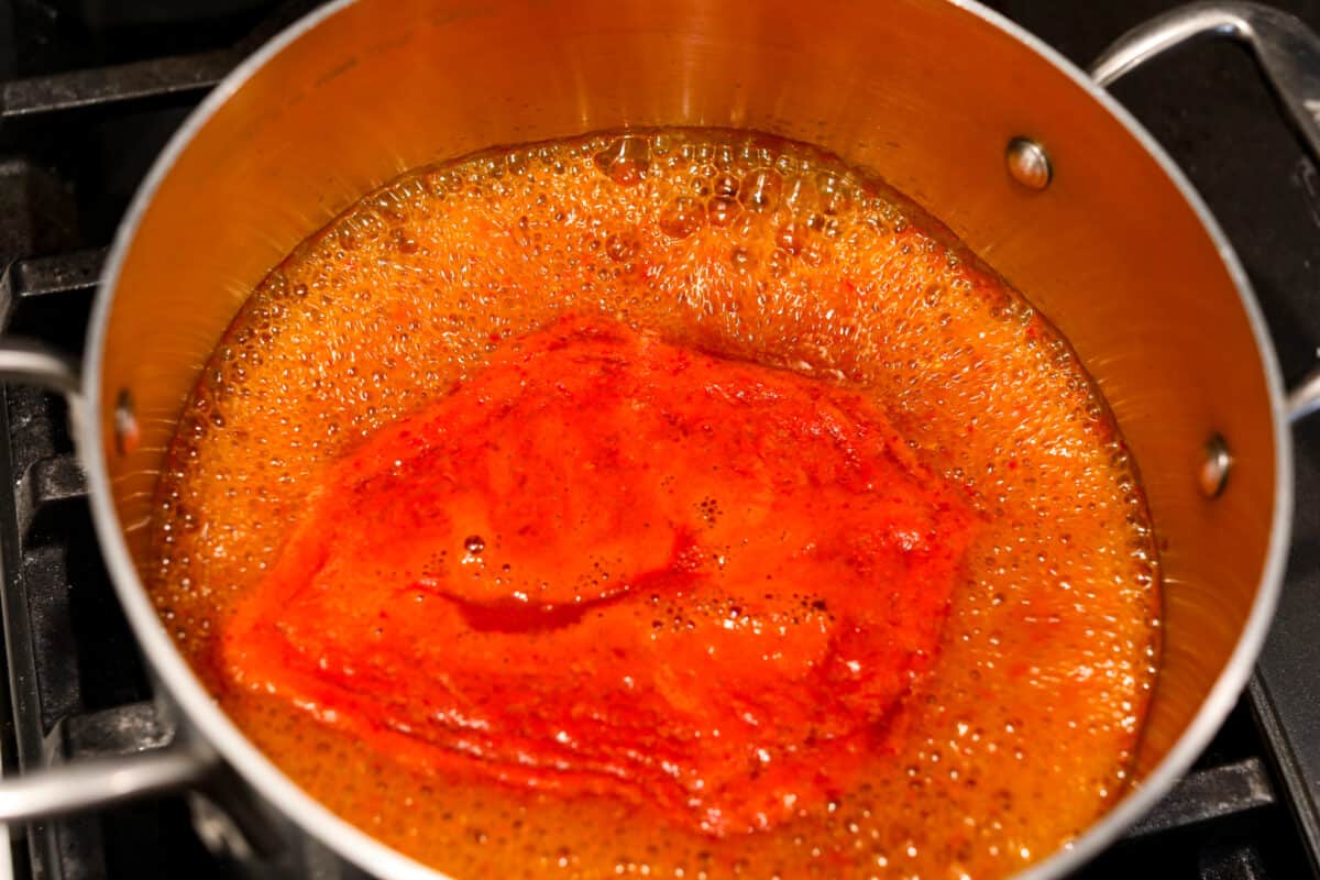 If hot sauce is something you use a lot in your kitchen, you have to try this homemade version! Tweak it to your liking then use it to upgrade all of your favorite dishes! Simmering all of the hot sauce ingredients together.
