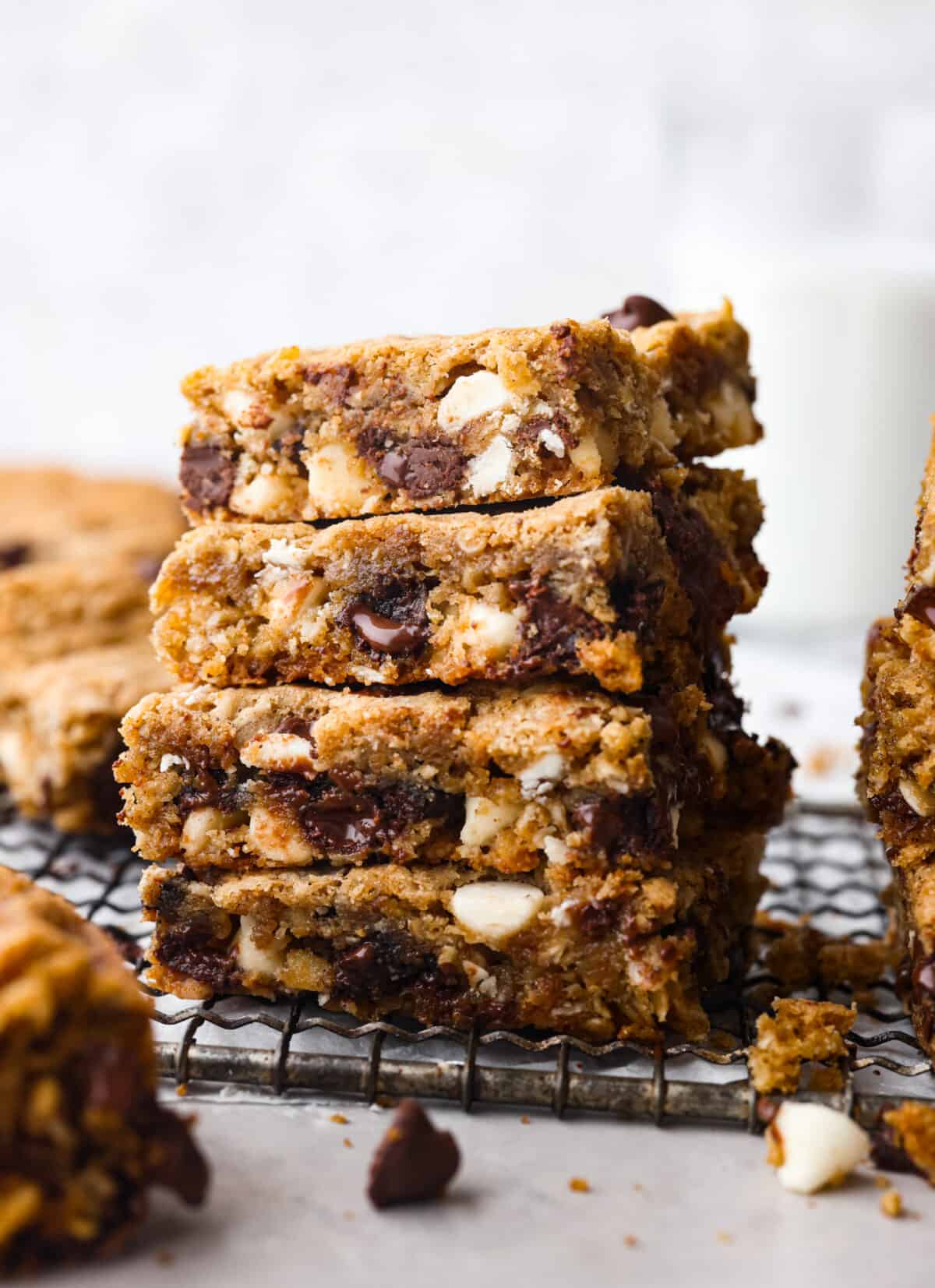 Win over everyoneโs heart (and stomach!) with these Marry Me Cookie Bars! They have the BEST flavor and texture, made with rolled oats, both white and semi-sweet chocolate chips, and a pinch of cinnamon! Chewy, creamy, chocolatey goodness! 4 marry me cookie bar slices stacked on top of each other.