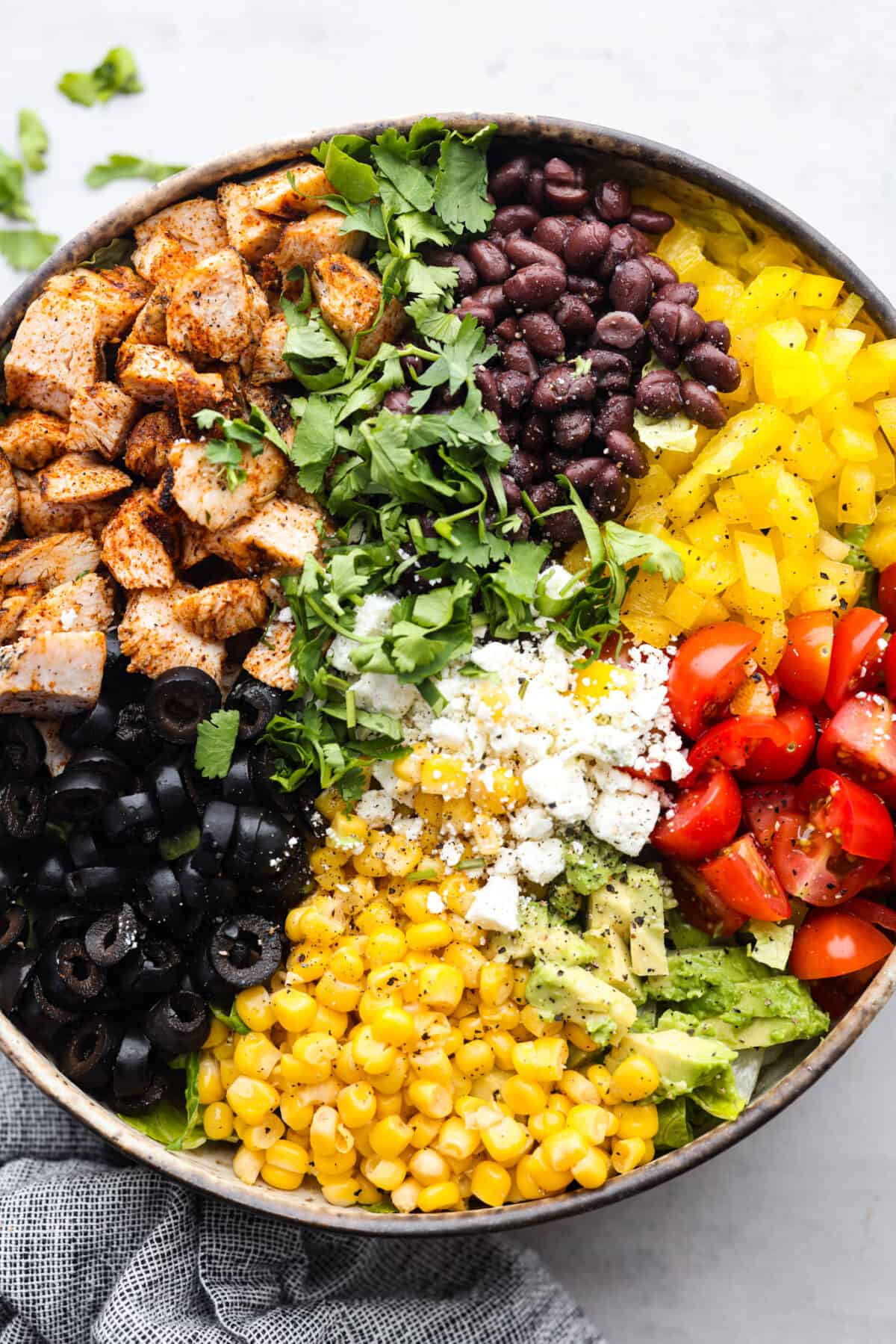 Santa Fe Salad is filled with bold southwestern flavor and has the most wonderful texture. Romaine lettuce, grilled chicken, black beans, corn, tomatoes, tortilla strips, avocado and cheese come together for the most amazing combination. And the creamy southwest dressing is the perfect finishing touch. A santa fe salad made with vibrant veggies, chicken, and cheese