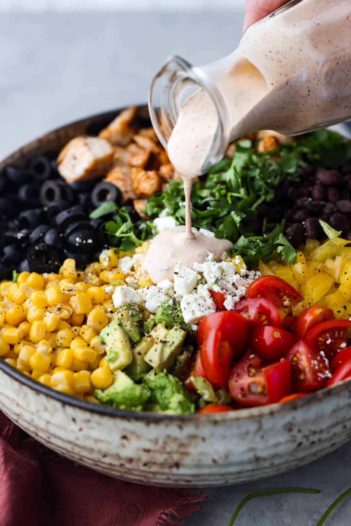 Santa Fe Salad is filled with bold southwestern flavor and has the most wonderful texture. Romaine lettuce, grilled chicken, black beans, corn, tomatoes, tortilla strips, avocado and cheese come together for the most amazing combination. And the creamy southwest dressing is the perfect finishing touch. Pouring dressing over the salad
