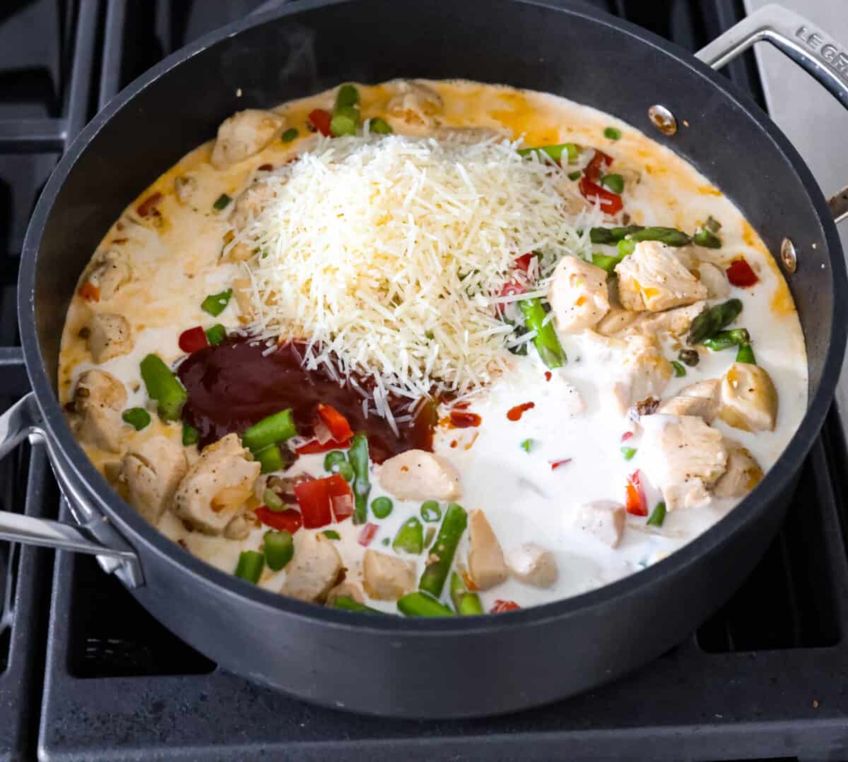 Spicy chicken chipotle pasta is so creamy and rich with a spicy kick that you won't be able to get enough of. The warm, smoky flavor of the chipotle peppers balanced with a flavorful cream sauce is sure to delight your tastebuds! It is a mouthwatering entree that everyone will love! Inspired by Cheesecake Factory, this homemade version is so tasty! The sauce ingredients being added to the skillet.