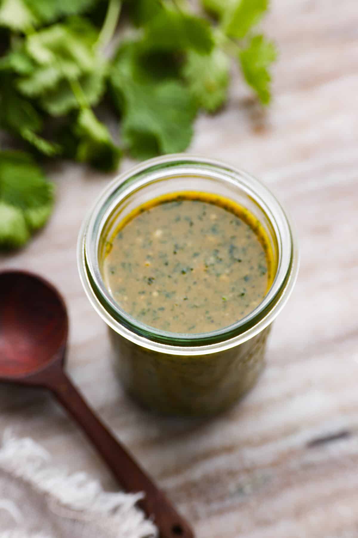 Craving the sweet, tangy flavor of the Cheesecake Factory's tamarind cashew dipping sauce? Look no further! This copycat recipe captures all the delicious flavors you love in a simple, homemade version that's ready in minutes. Green dipping sauce in a glass jar.