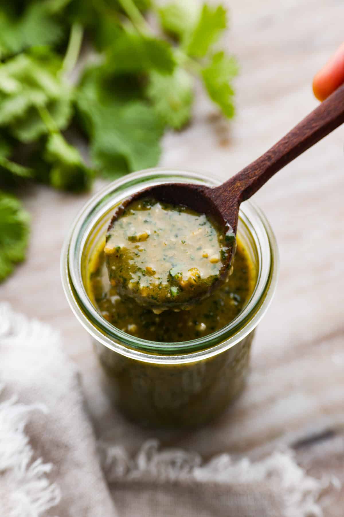 Craving the sweet, tangy flavor of the Cheesecake Factory's tamarind cashew dipping sauce? Look no further! This copycat recipe captures all the delicious flavors you love in a simple, homemade version that's ready in minutes. Tamarind cashew dipping sauce in a glass jar, being scooped up with a wooden spoon.