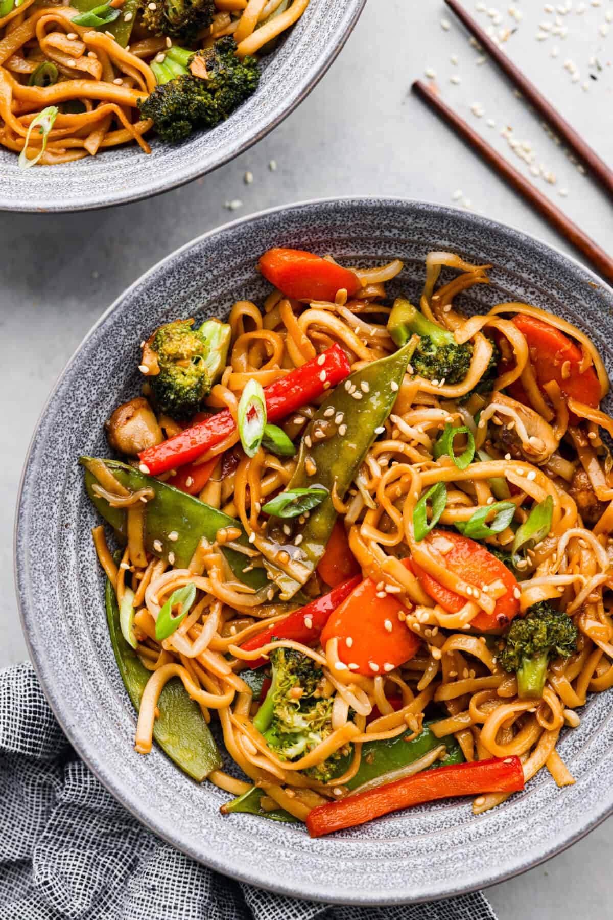 20-minute Vegetable Lo Mein is a super easy weeknight dish loaded with fresh, stir-fried veggies! A serving of vegetable lo mein in a gray bowl.
