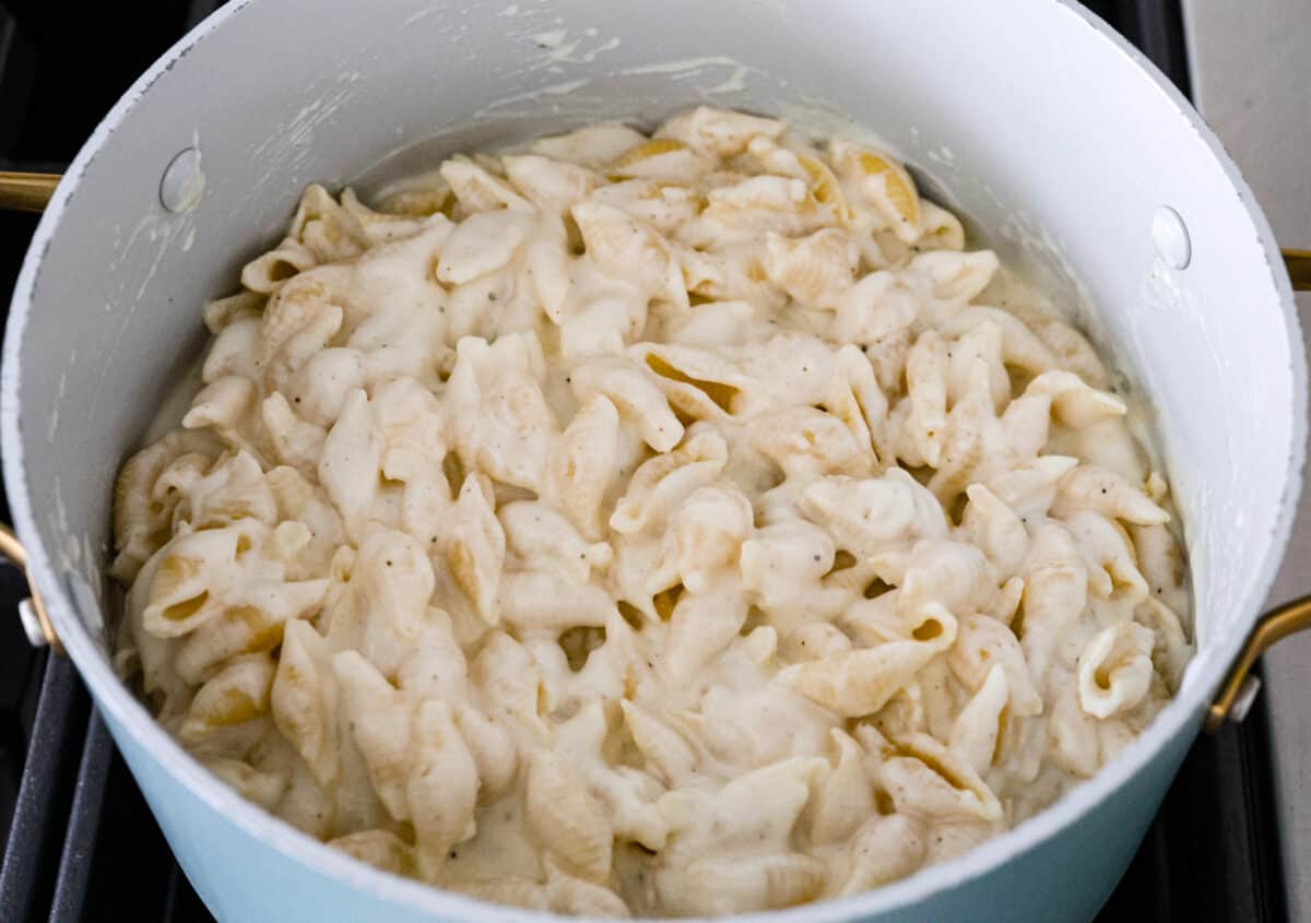 White Cheddar Mac and Cheese is super creamy and filled with rich, decadent flavor. This pasta recipe is the perfect comforting side dish for potlucks, holidays or even weeknight dinners! Stirring to combine