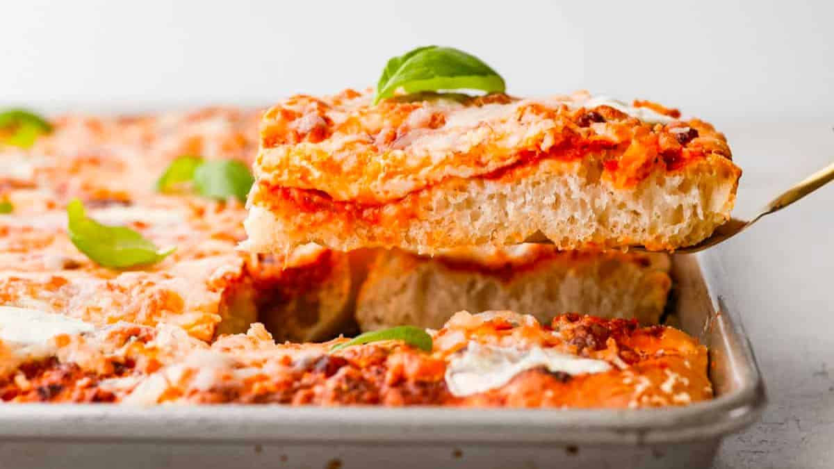 The best portable pizza ovens get hotter than the oven in your kitchen, so they deliver pizzeria-quality pizzas that are piping hot with crispy crusts and bubbly cheese Photo of a sheet pan pizza being served with a gold server.