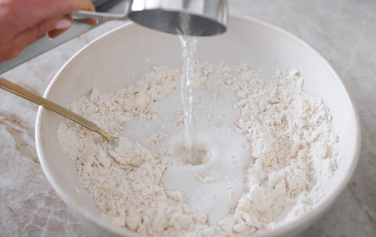 Tender and fluffyย 7-up biscuitsย rise to perfection and instantly become everyone's favorite biscuit! It only takes 4-ingredients to create this melt-in-your-mouth biscuit recipe! Second process photo of the 7 up pouring into the dough.