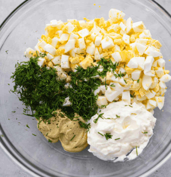 This egg salad has been a reader favorite for years because itโs creamy, simple, and lets the eggs shine. Itโs made with just a few ingredients, but the flavor is absolutely amazing and you can make it in just 25 minutes! A glass bowl with egg salad ingredients ready to be mixed together.