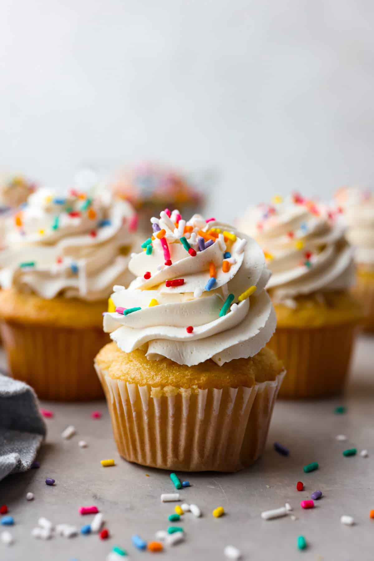 The most delicious Swiss Meringue Buttercream is easy to make with just 5 simple ingredients! It whips up deliciously light and silky with the right amount of sweetness. The perfect finishing touch for all of your favorite treats! A cupcake frosted with meringue buttercream and topped with multicolored sprinkles