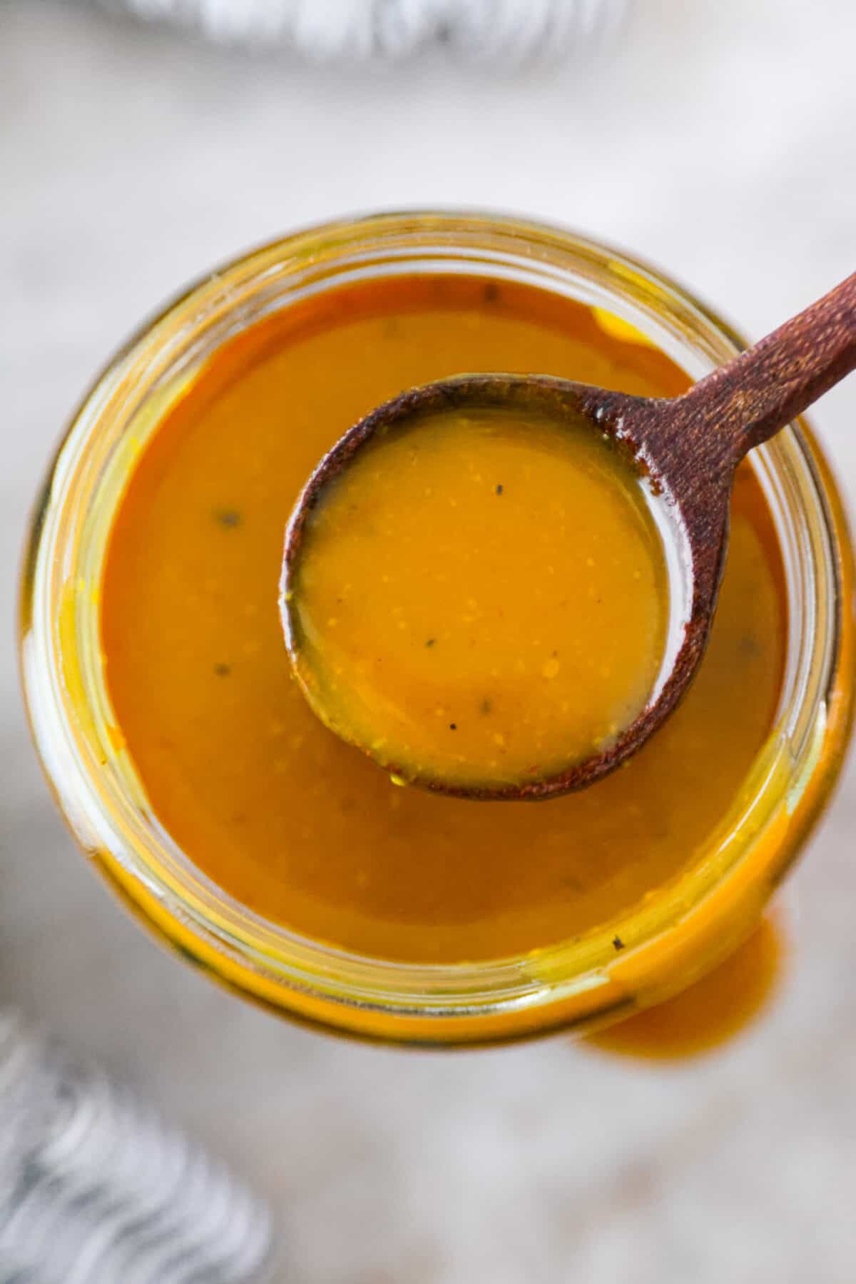 Smoky, tangy, and sweet, your taste buds will be begging you for more of this Mustard BBQ Sauce! It's the perfect addition to your summer cookouts this year, adding the best flavor to grilled meats! Top-down, closeup shot of mustard bbq sauce.