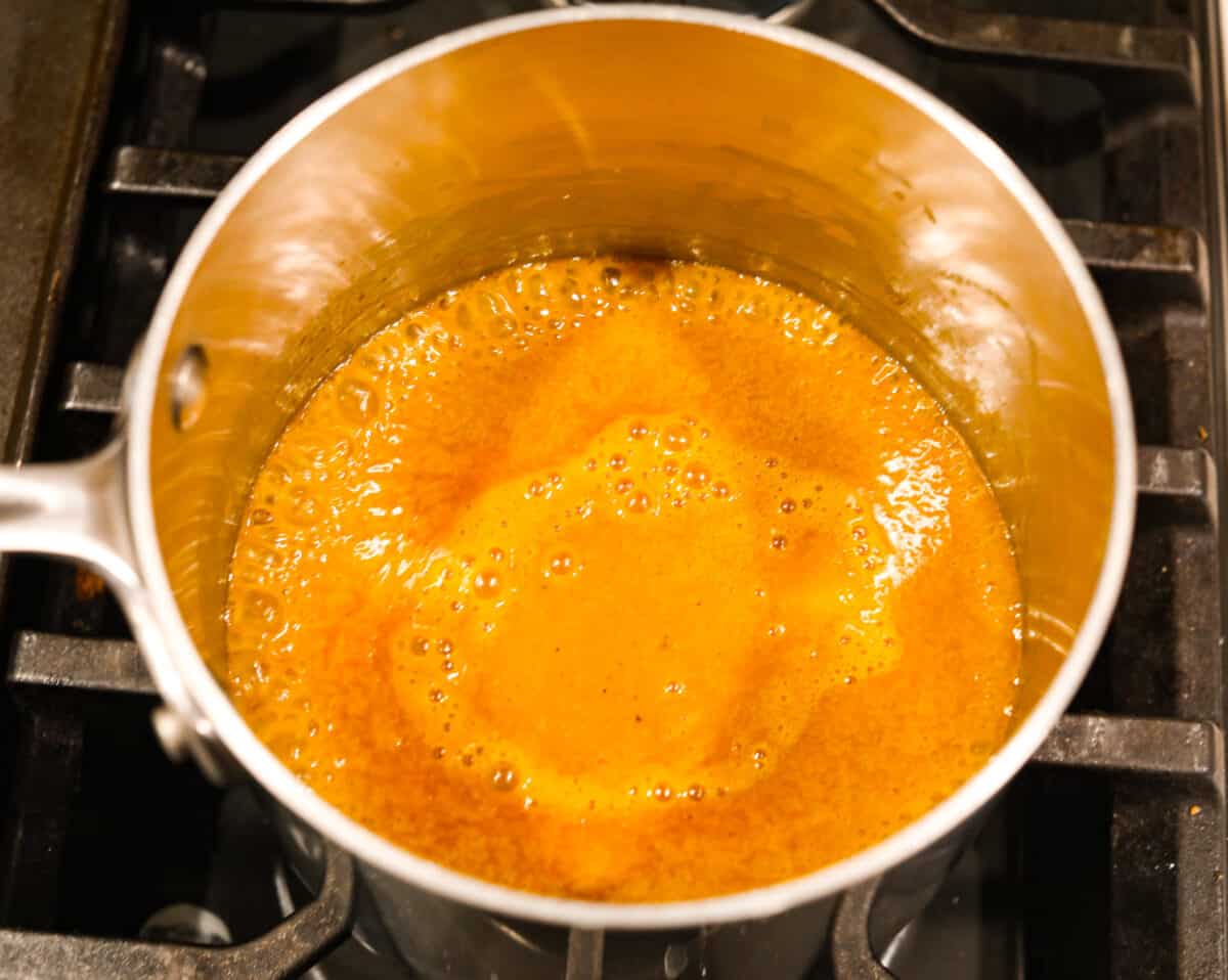 Smoky, tangy, and sweet, your taste buds will be begging you for more of this Mustard BBQ Sauce! It's the perfect addition to your summer cookouts this year, adding the best flavor to grilled meats! Combining and simmering the ingredients.