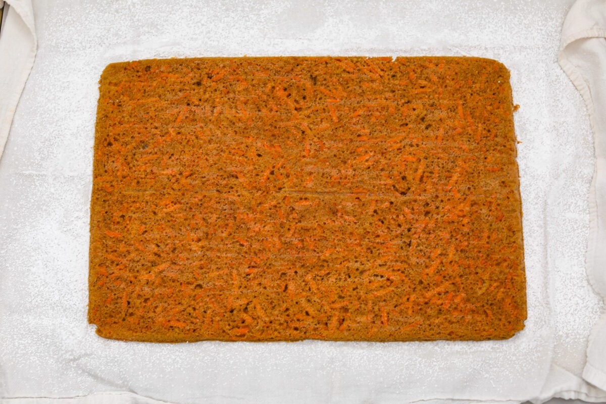 Stunning carrot cake roll is a wonderful joining of deliciously spiced carrot cake, swirled with tangy cream cheese frosting. It looks fancy but it's easy to make and so perfect for Easter and Spring themed celebrations! The cooked cake removed from the pan.