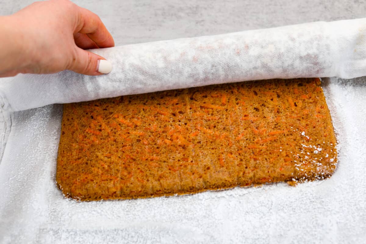 Stunning carrot cake roll is a wonderful joining of deliciously spiced carrot cake, swirled with tangy cream cheese frosting. It looks fancy but it's easy to make and so perfect for Easter and Spring themed celebrations! Rolling up the carrot cake