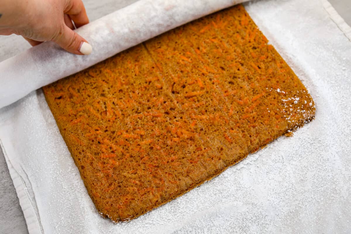 Stunning carrot cake roll is a wonderful joining of deliciously spiced carrot cake, swirled with tangy cream cheese frosting. It looks fancy but it's easy to make and so perfect for Easter and Spring themed celebrations! The carrot cake being unrolled