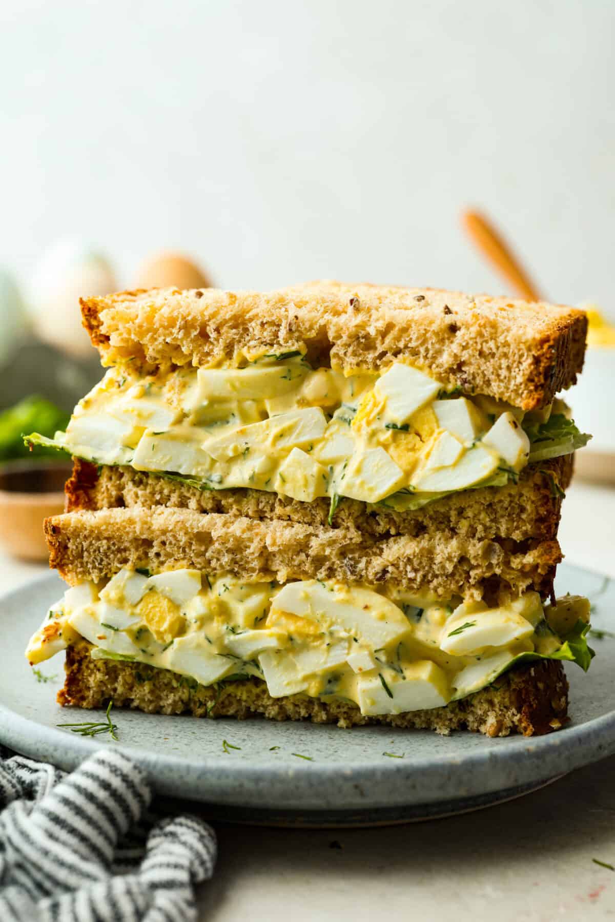 This egg salad has been a reader favorite for years because itโs creamy, simple, and lets the eggs shine. Itโs made with just a few ingredients, but the flavor is absolutely amazing and you can make it in just 25 minutes! The side view of a sliced egg salad sandwich stacked on each other.