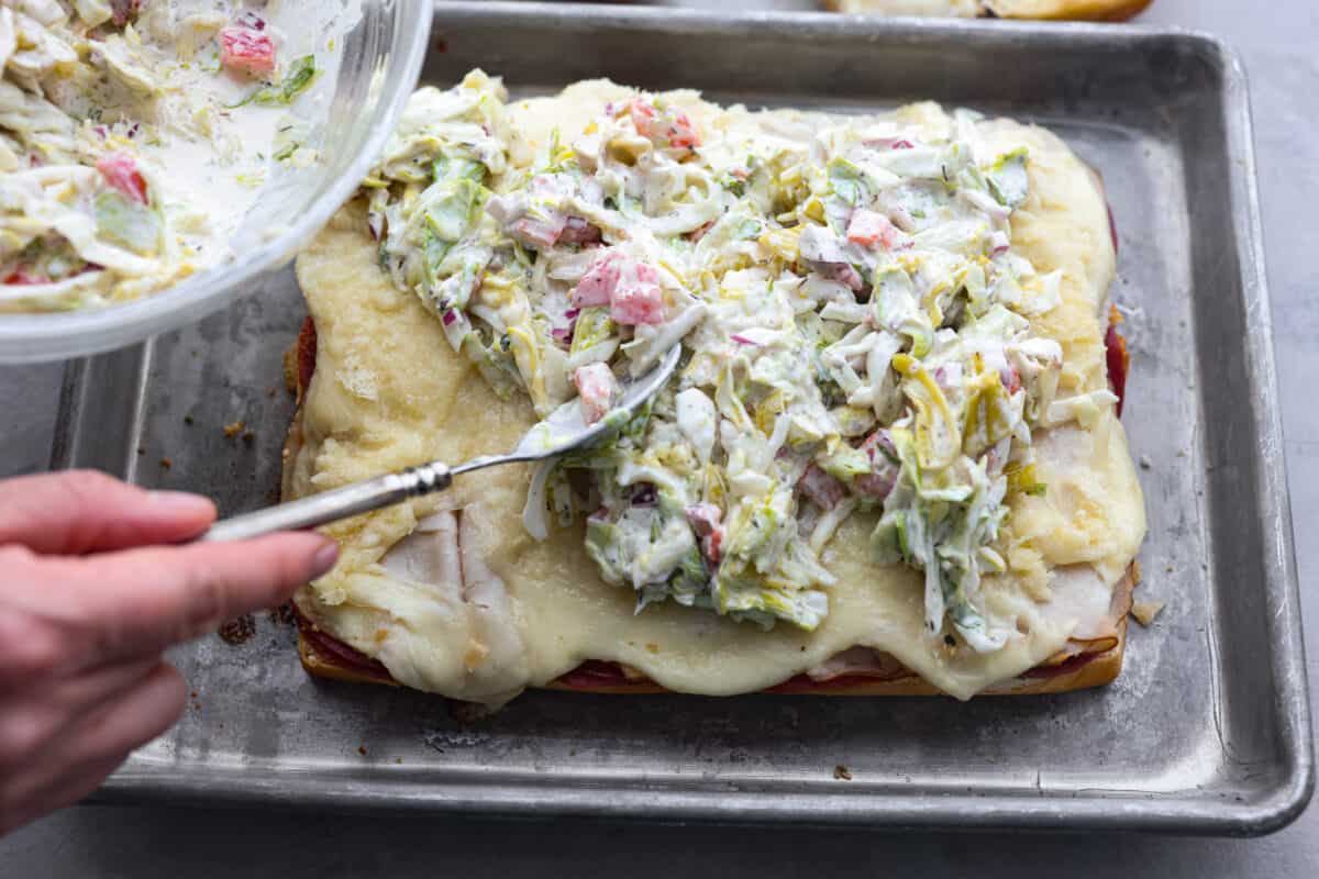 The classic grinder sandwich made into sliders to share! You've got Hawaiian rolls topped with layers of pepperoni, salami, turkey, provolone, and creamy grinder salad. And to top things off- each roll is brushed with a buttery parmesan glaze and baked to golden brown perfection. Adding the salad to the sliders