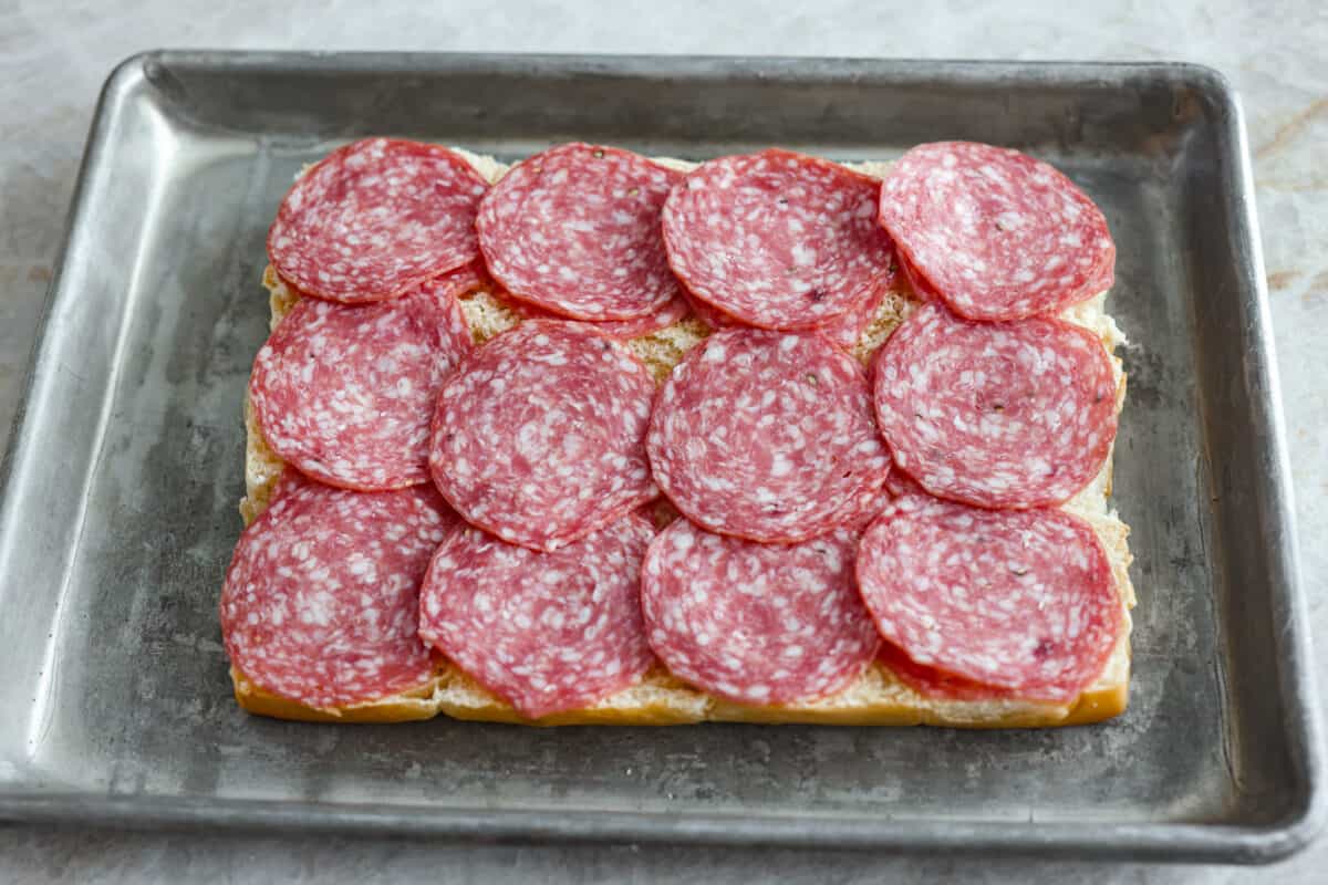 The classic grinder sandwich made into sliders to share! You've got Hawaiian rolls topped with layers of pepperoni, salami, turkey, provolone, and creamy grinder salad. And to top things off- each roll is brushed with a buttery parmesan glaze and baked to golden brown perfection. Adding the salami layer to the grinder sliders