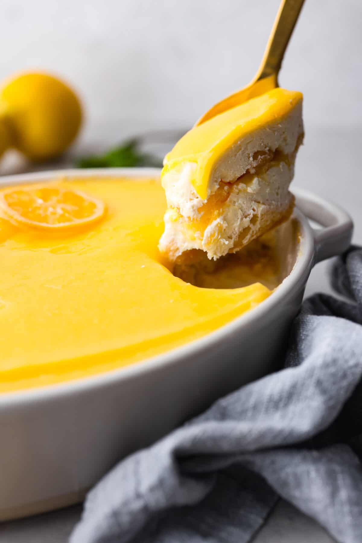 Meet lemon tiramisu! The most amazing citrusy twist on a classic Italian dessert. The layers of mascarpone cream and lemon curd will have you reaching for another slice! A scoop of lemon tiramisu.