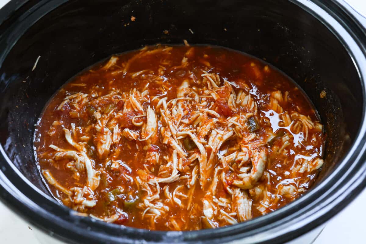 Weeknight dinner made easy with this crockpot salsa chicken! Tender flavorful chicken that only takes 5 ingredients to make. It's a versatile recipe the whole family will love! Shredded chicken added back to the slow cooker.