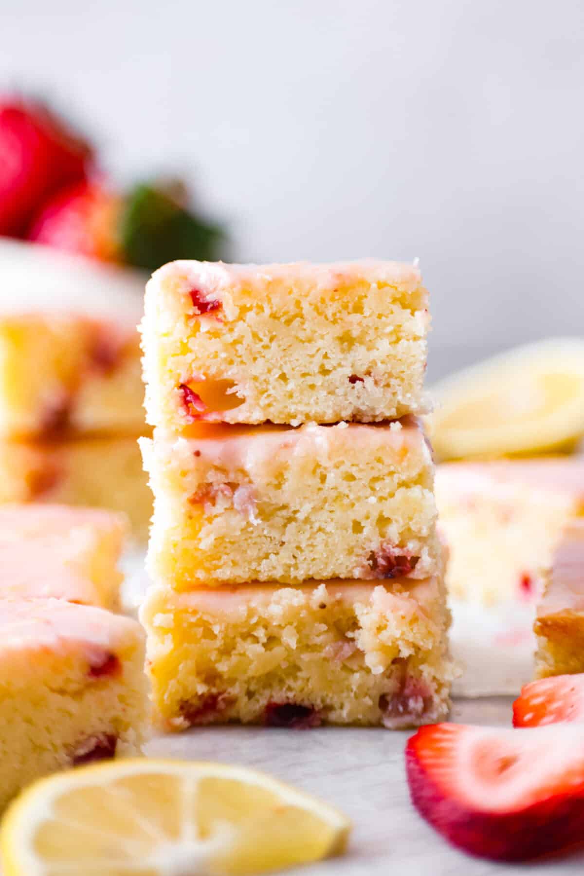 Tender and moist, strawberry lemon blondies are loaded with plenty of sweet, juicy strawberries that are joined with just enough tangy lemon flavor. These amazing bars are buttery, thick and the perfect spring and summer dessert! 3 strawberry lemon blondie slices stacked on top of each other.