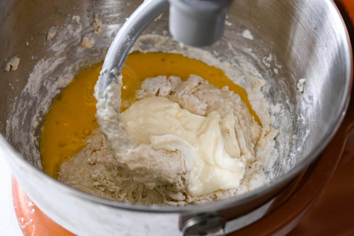 Perfectly soft buttery rolls will be your classic go-to roll recipe! They are tender fluffy, and baked with a buttery golden top. These rolls are sure to be a family favorite! Third process photo of the flour, yeast, eggs, and butter kneading in a mixing bowl.