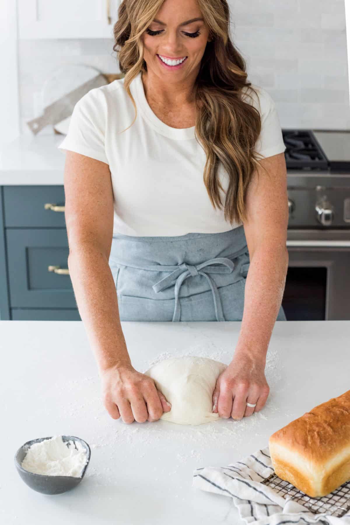 You want to make bread, but where do you start? My beginner's guide to baking bread is here to save the day! Feel confidentย at bread-making while I hold your hand through the whole process. Close view of Alyssa kneading bread for this beginner's guide to baking bread.