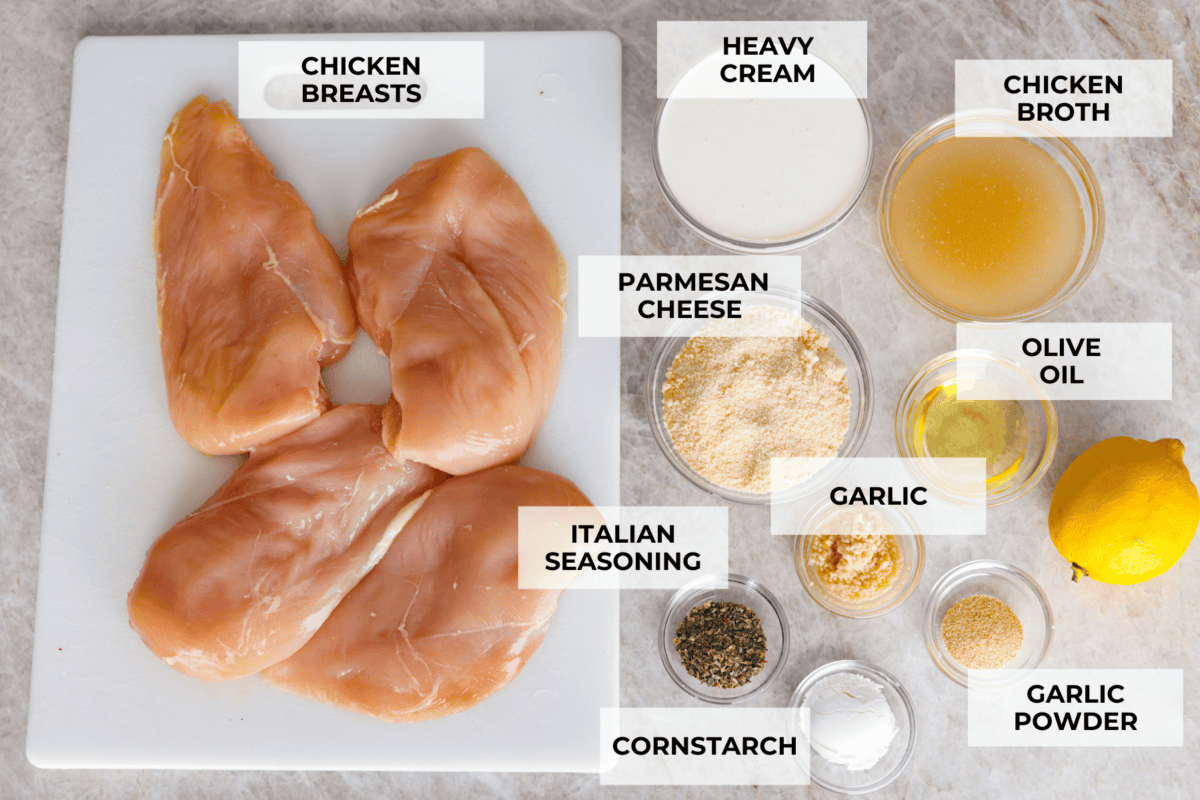 Creamy Lemon Parmesan Chicken is an incredible restaurant-quality meal you can make in under 30 minutes. The key is to sear the chicken to seal in all of the juices and flavor. Then, it is smothered in an irresistible creamy lemon parmesan sauce. Overhead shot of labeled creamy lemon parmesan chicken ingredients.