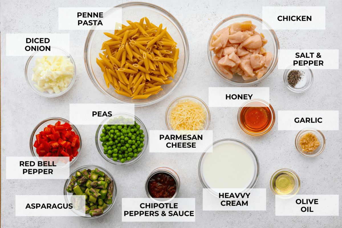 Spicy chicken chipotle pasta is so creamy and rich with a spicy kick that you won't be able to get enough of. The warm, smoky flavor of the chipotle peppers balanced with a flavorful cream sauce is sure to delight your tastebuds! It is a mouthwatering entree that everyone will love! Inspired by Cheesecake Factory, this homemade version is so tasty! All of the ingredients for the chipotle pasta separated into glass bowls. Listed are: diced onion, penne pasta, chicken, salt and pepper, red bell pepper, peas, parmesan cheese, honey, garlic, asparagus, chipotle peppers, heavy cream, and olive oil.