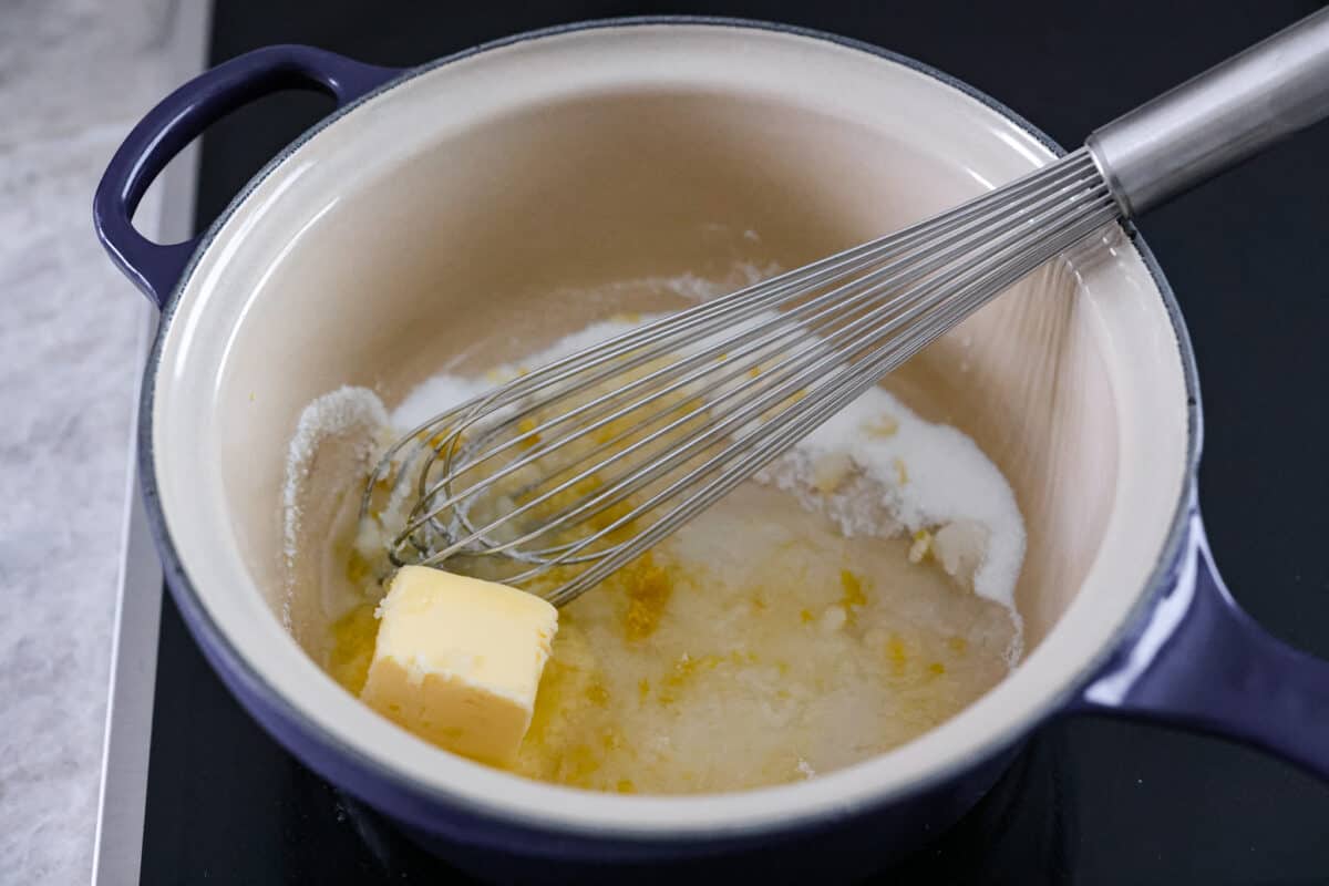 Be prepared to fall in love with this blueberry lemon upside-down cake! A delicious and moist lemon sponge cake bursting with juicy caramelized blueberries on top! First photo of butter, sugar, lemon juice and zest in a saucepan.