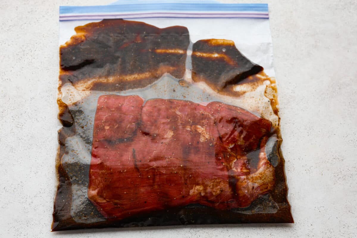 This delicious California Burrito is filled with well-seasoned grilled steak, pepper jack cheese, French fries, pico de Gallo, sour cream and avocado, all wrapped up in a warm flour tortilla. A flavorful lunch or dinner option that will be an absolute hit! Skirt steak marinating in a plastic bag for the California burritos.