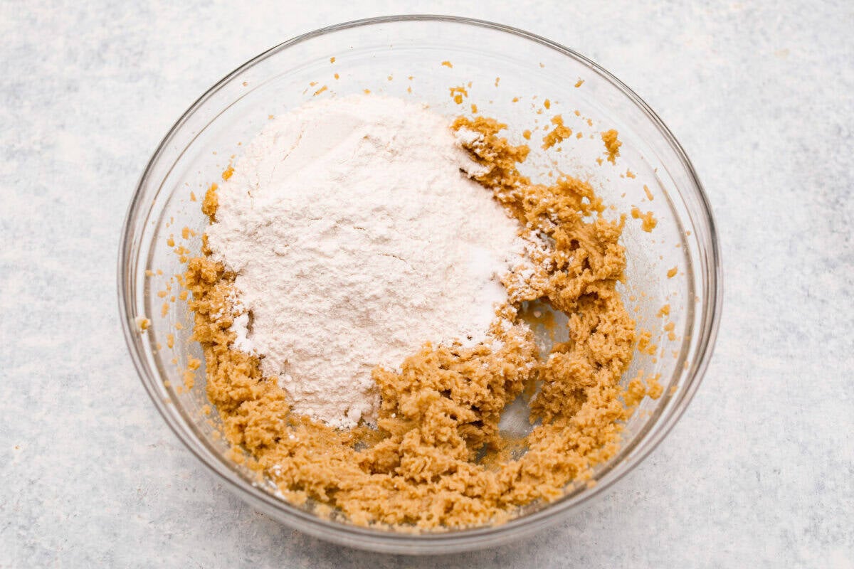 I am so excited about this recipe, it combines two of my all-time favorite desserts, cookie dough and cheesecake! With the rich Oreo crust, creamy cheesecake filling, and edible cookie dough bites, this no-bake cookie dough cheesecake will have your taste buds begging for more! Overhead shot of a bowl with some mixed ingredients and flour.