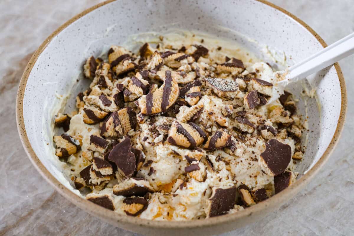 Serve this fun and delicious cookie salad as a dessert or side dish! Everyone will love the sweet fluffy pudding base mixed with mandarin oranges, crushed pineapple, and fudge stripes cookies. Fourth process photo of the cookies folding into the cookie salad.