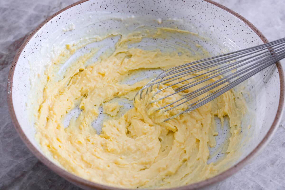 Serve this fun and delicious cookie salad as a dessert or side dish! Everyone will love the sweet fluffy pudding base mixed with mandarin oranges, crushed pineapple, and fudge stripes cookies. First process photo of the buttermilk and pudding mixed in a bowl.
