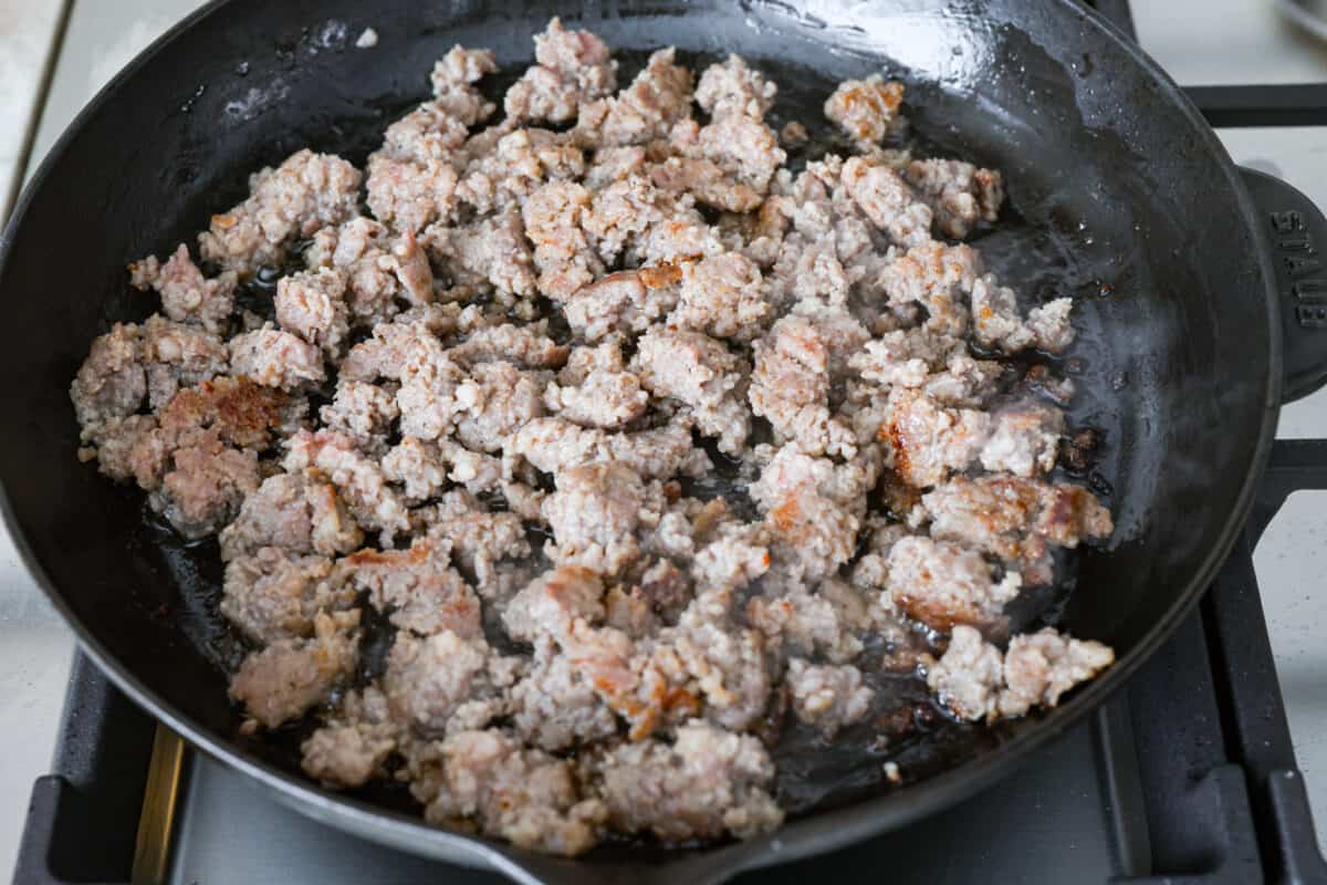 Get ready to rustle up some serious flavor with this Cowboy Queso! Packed with zesty sausage, hearty beans, and a kick of beer, it's the perfect dip for any gathering—just grab your tortilla chips and dig in! Cooked sausage in a skillet.