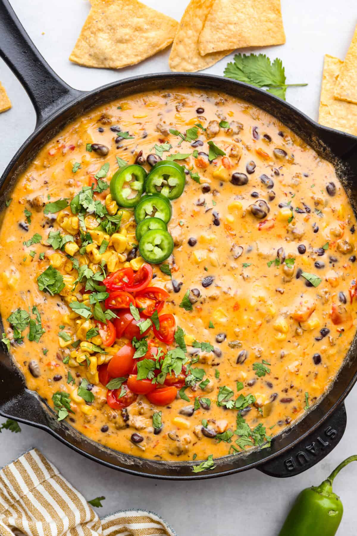 Get ready to rustle up some serious flavor with this Cowboy Queso! Packed with zesty sausage, hearty beans, and a kick of beer, it's the perfect dip for any gathering—just grab your tortilla chips and dig in! Cowboy queso in a skillet.