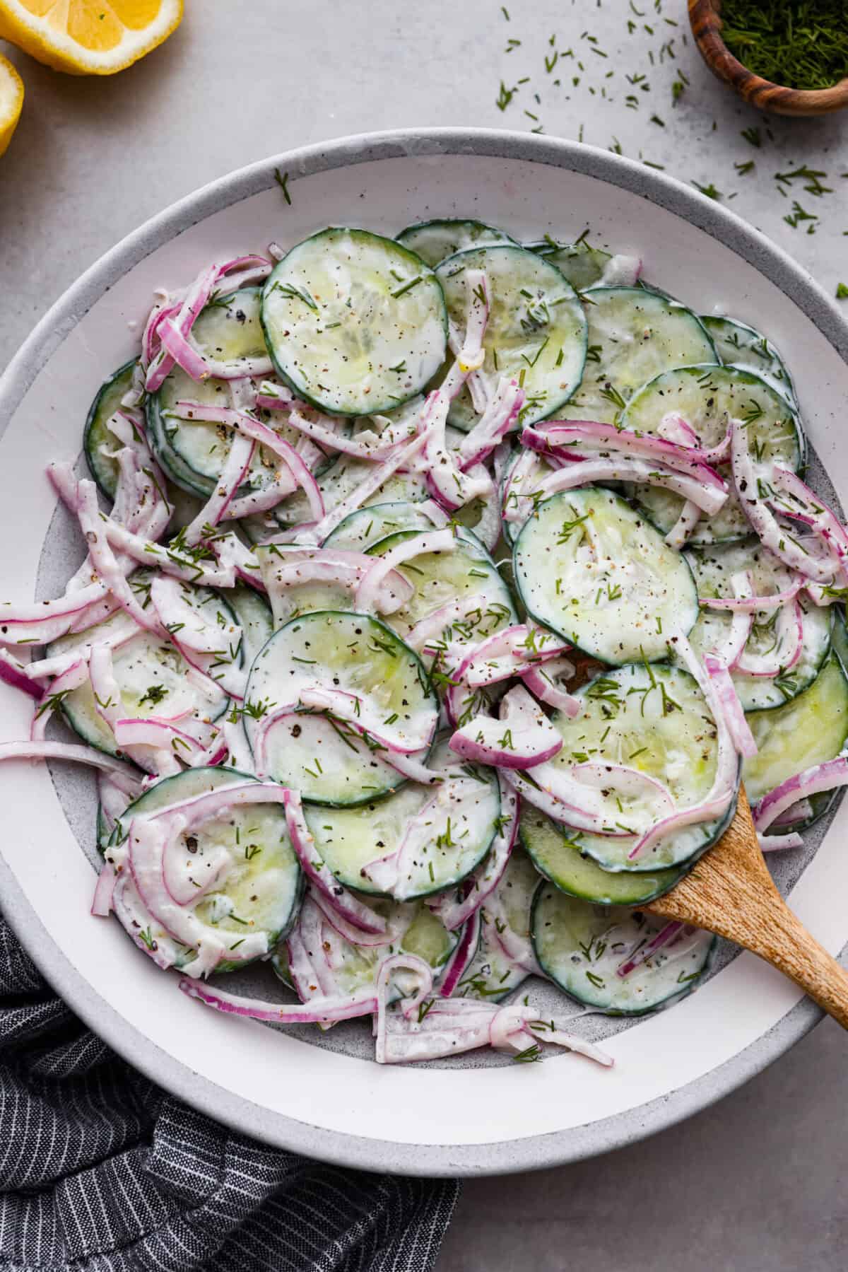 Creamy Cucumber Salad is a delicious and refreshing side dish. All it takes is a handful of fresh simple ingredients and 15 minutes. This is the perfect addition to your next summer barbecue! Creamy cucumber salad in a bowl.