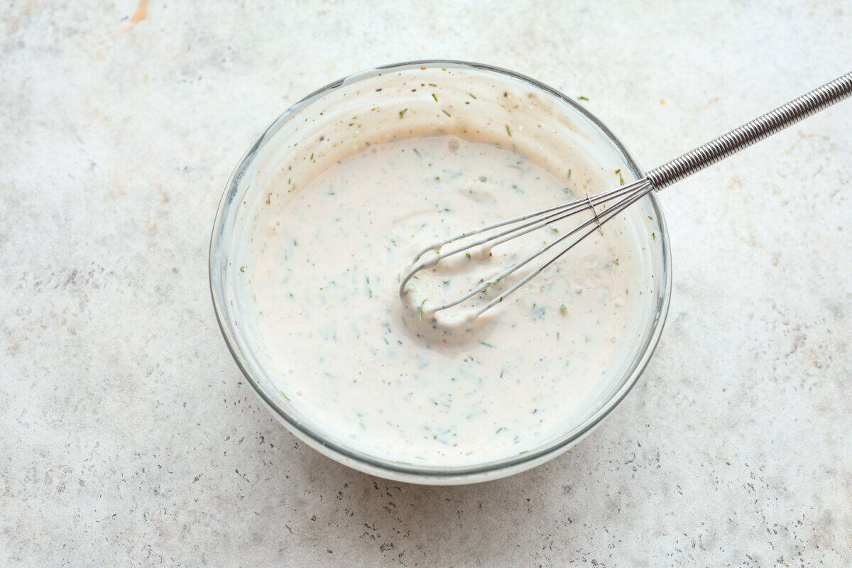 Creamy Cucumber Salad is a delicious and refreshing side dish. All it takes is a handful of fresh simple ingredients and 15 minutes. This is the perfect addition to your next summer barbecue! Dressing ingredients mixed with a whisk.