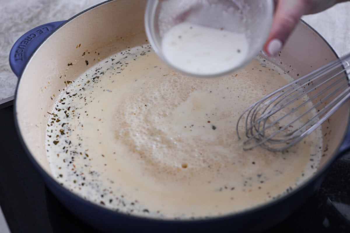 Creamy Lemon Parmesan Chicken is an incredible restaurant-quality meal you can make in under 30 minutes. Tender, juicy chicken is smothered in a creamy lemon parmesan sauce- itโs a meal the family will go crazy for!ย Adding the sauce ingredients to the skillet.