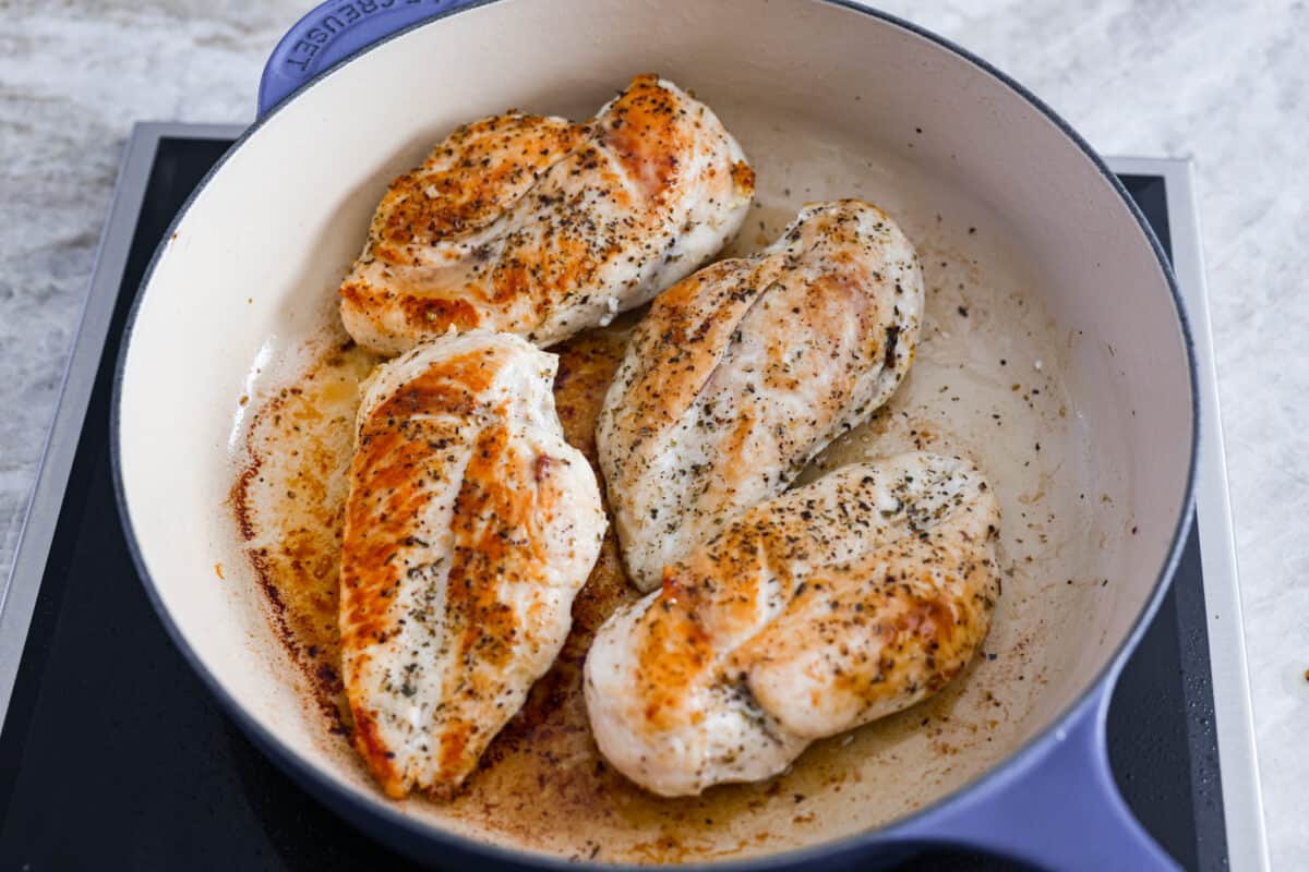 Creamy Lemon Parmesan Chicken is an incredible restaurant-quality meal you can make in under 30 minutes. Tender, juicy chicken is smothered in a creamy lemon parmesan sauce- itโs a meal the family will go crazy for!ย Searing the chicken in a skillet.