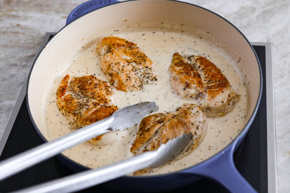 Creamy Lemon Parmesan Chicken is an incredible restaurant-quality meal you can make in under 30 minutes. Tender, juicy chicken is smothered in a creamy lemon parmesan sauce- itโs a meal the family will go crazy for!ย Combining the sauce with the cooked chicken.