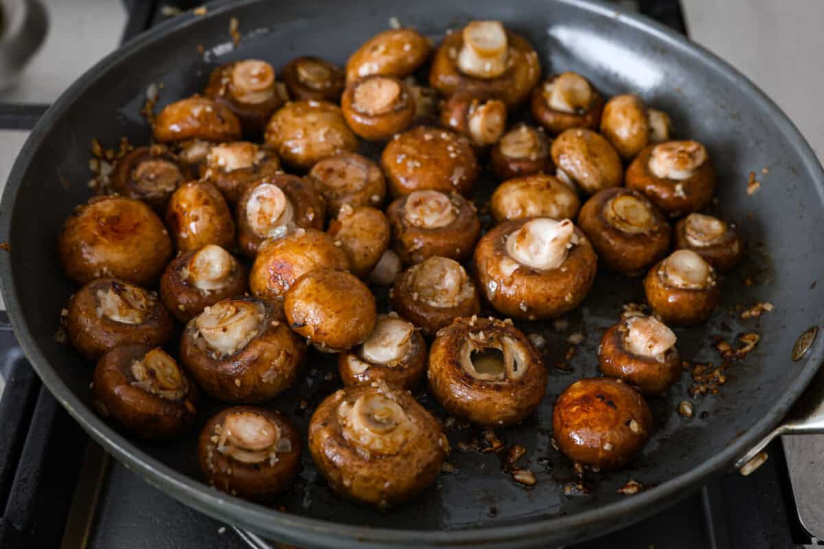 The depth of flavors in these garlic balsamic mushrooms is next level! Sauteed mushrooms are coated in a sweet balsamic sauce loaded with herbs. It's a simple and impressive side dish that only takes minutes to prepare. First photo of the mushrooms, onions, and garlic sautรฉing.