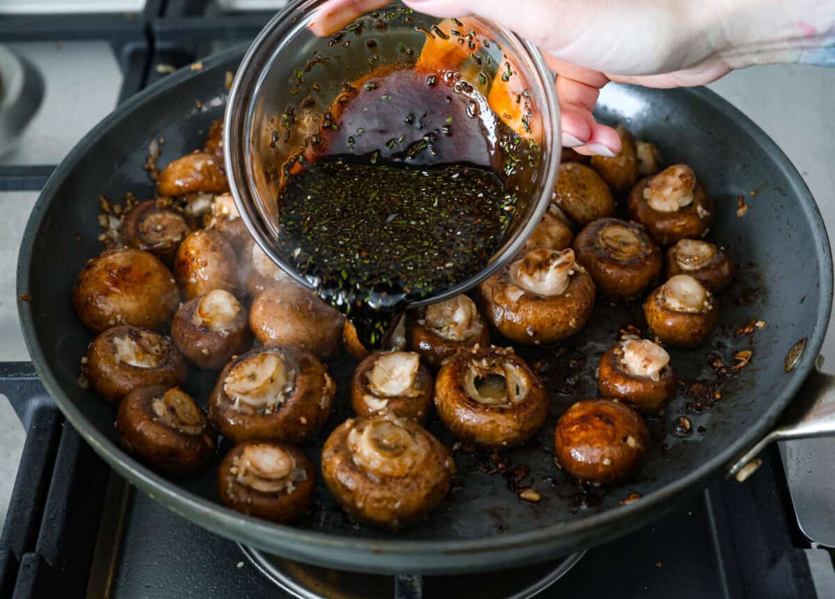 The depth of flavors in these garlic balsamic mushrooms is next level! Sauteed mushrooms are coated in a sweet balsamic sauce loaded with herbs. It's a simple and impressive side dish that only takes minutes to prepare. Fourth photo of the sauce pouring over the mushroom mixture.