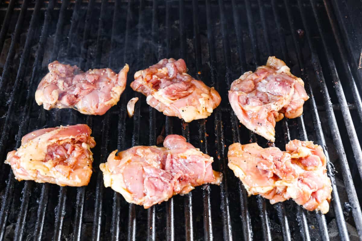 One bite of this grilled bourbon chicken and your tastebuds will be dancing with delight! It's marinated in a flavorful homemade bourbon sauce that tastes amazing. You will be making it on the regular once you see what a huge hit it is! Chicken thighs being marinated on the grill.
